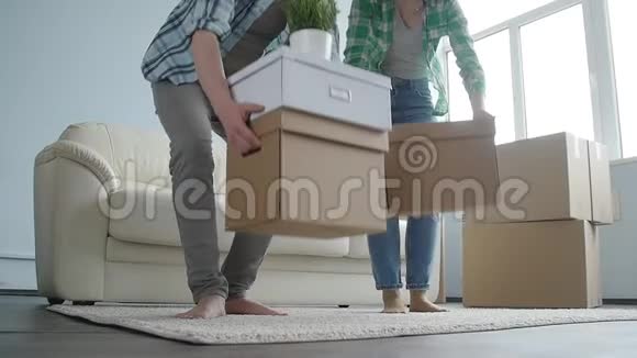 带着纸板箱的快乐年轻夫妇搬到新公寓视频的预览图