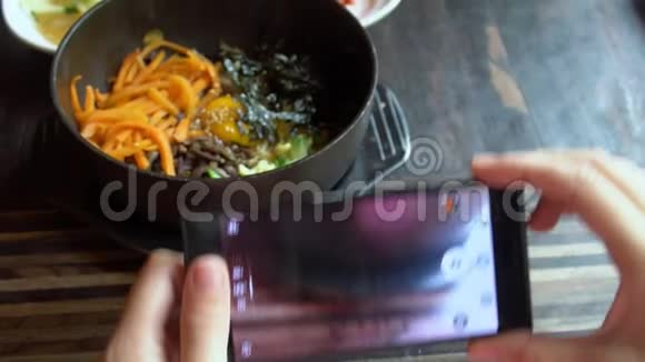 用手机拍摄韩国传统菜肴Bibimbap和小配菜clledbanchan的食物照片视频的预览图
