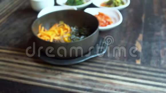 用手机拍摄韩国传统菜肴Bibimbap和小配菜clledbanchan的食物照片视频的预览图