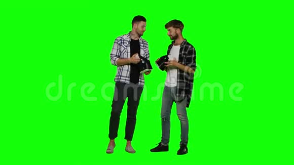 两个带虚拟现实耳机的年轻人绿色屏幕视频的预览图