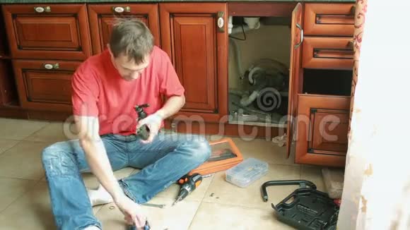 卫生工程补漏男人在厨房里修水龙头视频的预览图