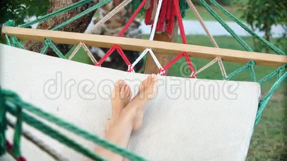 女人的腿在户外吊床上摆动视频的预览图