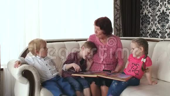 祖母带着孙子孙女看相册视频的预览图