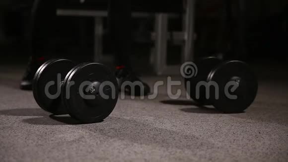 运动赤膊青年运动员健身模特在健身房里拿着哑铃特写视频的预览图