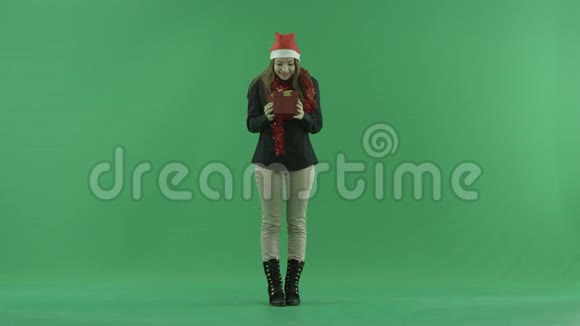 年轻女子打开空的圣诞礼盒绿色彩色钥匙背景视频的预览图
