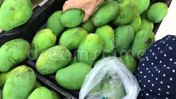 女手在超市采摘新鲜有机芒果食品购物视频的预览图