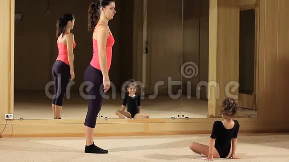 教一个体操小女孩伸展一个小体操运动员和教练订婚了视频的预览图