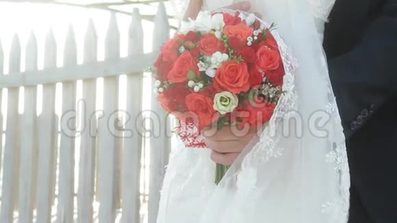 新娘手中喜庆的红玫瑰花束视频的预览图