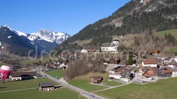 一个热气球在雪上飞行覆盖了瑞士中部高山高峰视频的预览图