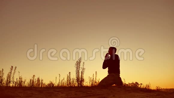 在美丽的风景中祈祷的人的剪影插图视频的预览图