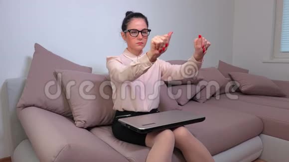 女人坐在沙发上放松疲惫的双手视频的预览图