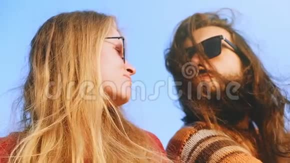 太阳眼镜的年轻夫妇在日出时拥抱亲吻视频的预览图