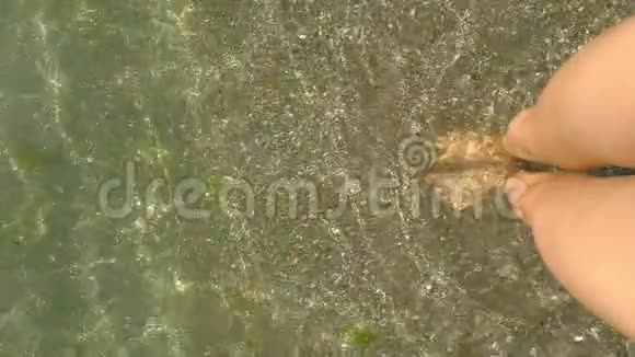 女人的腿走在金色的沙滩上溅起海水个人视野慢动作视频的预览图