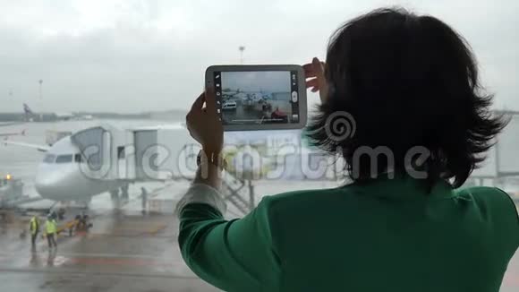 在机场的女人飞机从窗户拍照视频的预览图