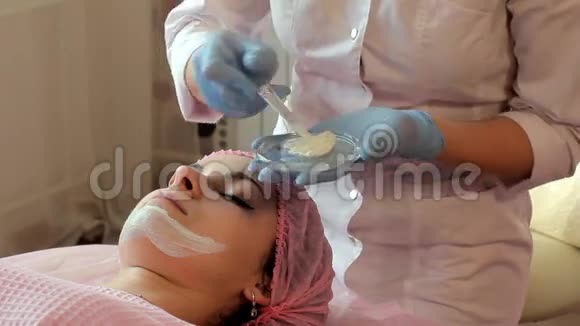 美容师用刷子把面具戴在美女的脸上视频的预览图