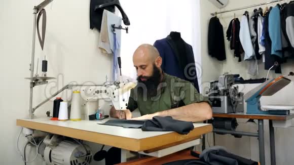 一位裁缝在他的工作室工作在桌子上视频的预览图