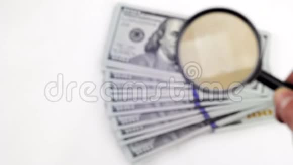 用放大镜检查一百美元钞票上的水印视频的预览图