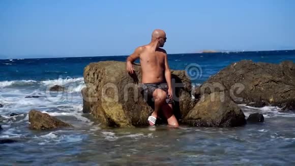 在岩石海滩上的年轻帅哥视频的预览图