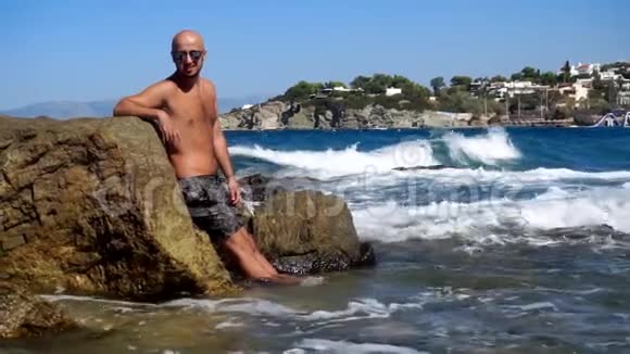 在岩石海滩上的年轻帅哥视频的预览图