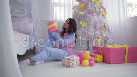 女孩在白色地毯上打开礼物视频的预览图