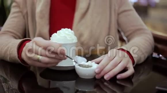 女人在咖啡里加入棉花糖和奶油视频的预览图