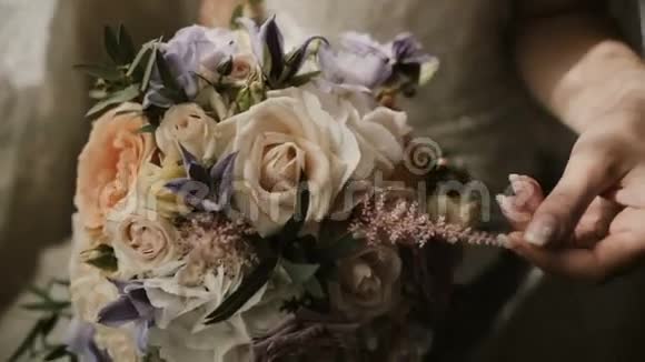 年轻漂亮的新娘捧着婚礼花束特写观女触花前礼视频的预览图