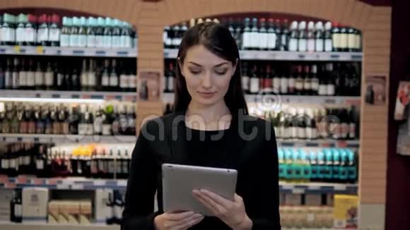 酒店的美容师店里的阿曼根据核对单或平板电脑中的信息选择葡萄酒视频的预览图