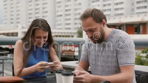 漂亮的年轻夫妇在智能手机上在线玩游戏她赢了他输了4千视频的预览图