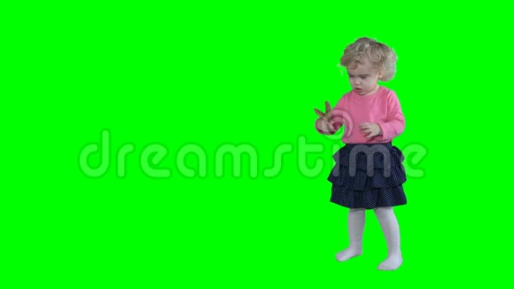 可爱的小女孩把金色的派对眼镜戴在头上孤立地戴在绿色上视频的预览图