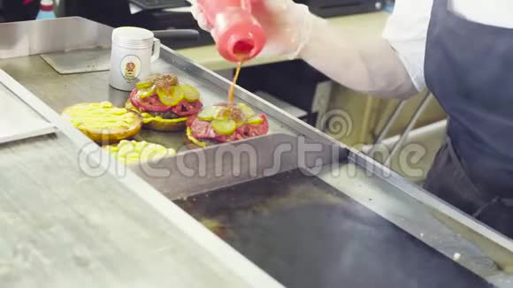 厨师把沙拉放在一个现成的汉堡上视频的预览图