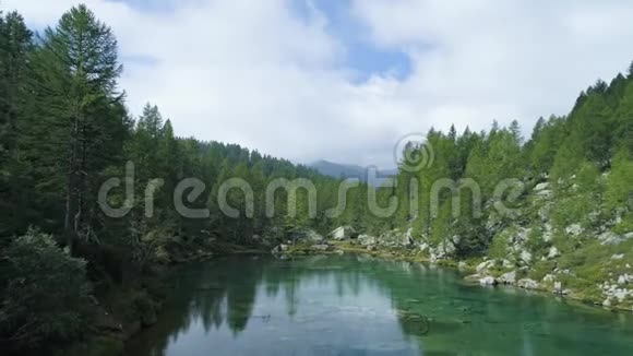 在阳光明媚的夏天在蓝色的高山湖上空盘旋露出山林山谷欧洲阿尔卑斯山视频的预览图
