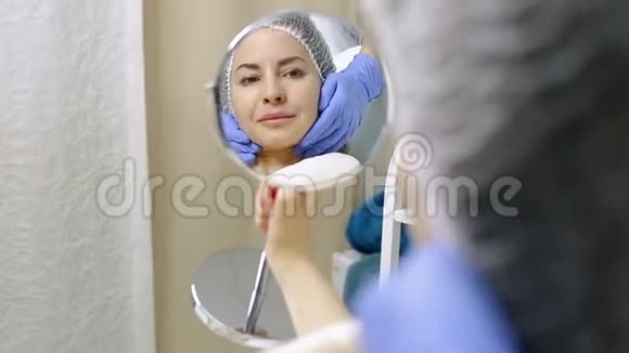 美丽的女人在美容院做过整容手术后照镜子视频的预览图