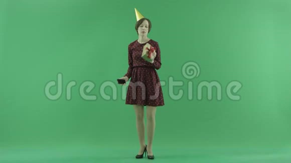 一个年轻的女人正在用她的礼物在绿色屏幕上自拍视频的预览图