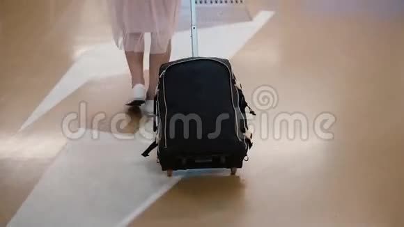 年轻的女旅行者带着手提箱穿过机场女人穿过停车场在城里出门视频的预览图