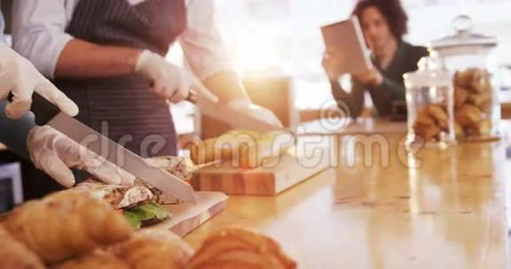 服务员和服务员在柜台上切面包面包和三明治视频的预览图