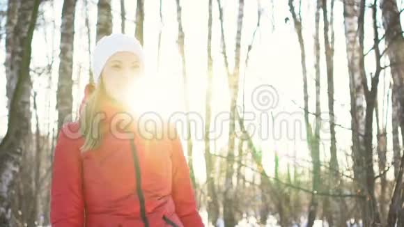 美丽的年轻女子在阳光明媚的冬季公园里玩雪球玩得开心微笑慢动作视频的预览图