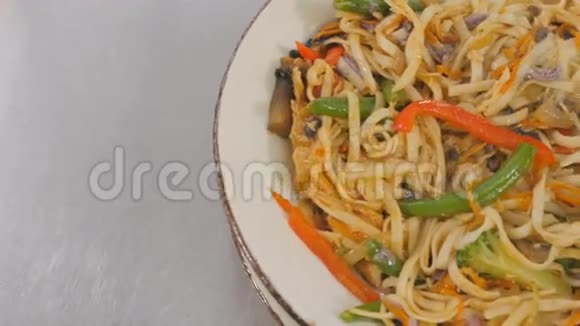 白色盘子里有蔬菜和肉的美味意大利面视频的预览图