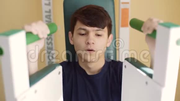 一个有听力障碍的15岁男孩在健身房训练助听器里的人在健身房视频的预览图
