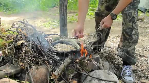 人在火上煎鱼炸淡水鱼格雷林火上煎锅里烤的鱼视频的预览图