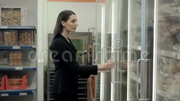 布鲁内特从冰箱里挑选冷冻面包女士在超市挑选面包视频的预览图