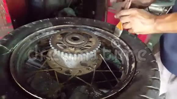 特写男清理平衡机上的轮胎视频的预览图