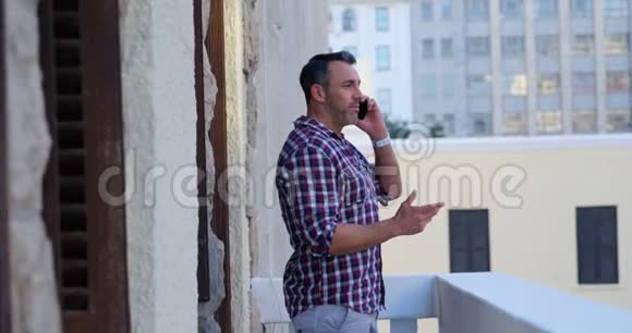 男子在4k阳台上讲手机视频的预览图