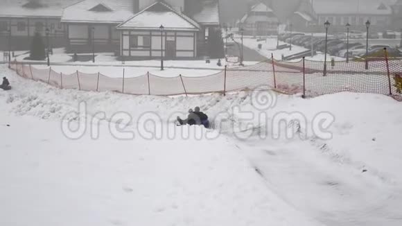 快乐的女孩在雪地上骑着微笑的雪筒视频的预览图