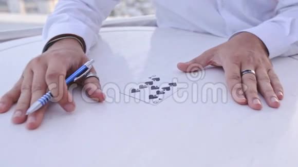 特写魔术师在白色桌子上用钢笔标记阴影卡视频的预览图