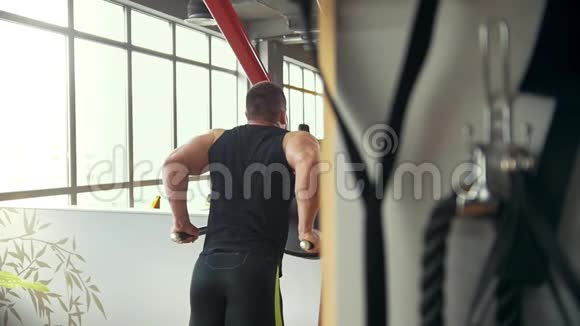 健身房肌肉男锻炼的后视图视频的预览图