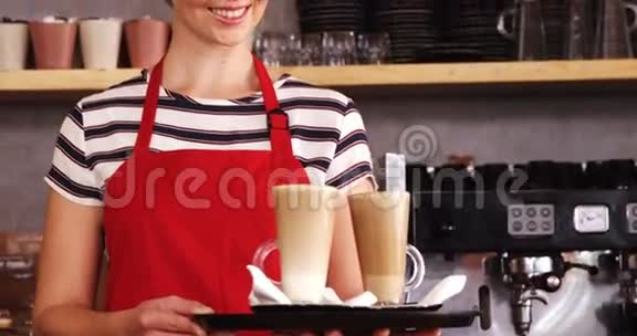 微笑的女服务员在柜台端着一杯冷咖啡视频的预览图
