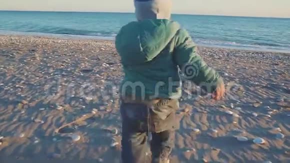 宝宝的生活方式那个男孩在日落时跑到海里假日概念视频的预览图