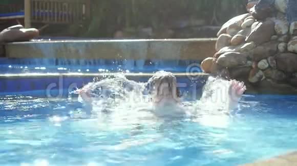 动作缓慢英俊的小孩在游泳池里尽情泼水镜头闪烁视频的预览图