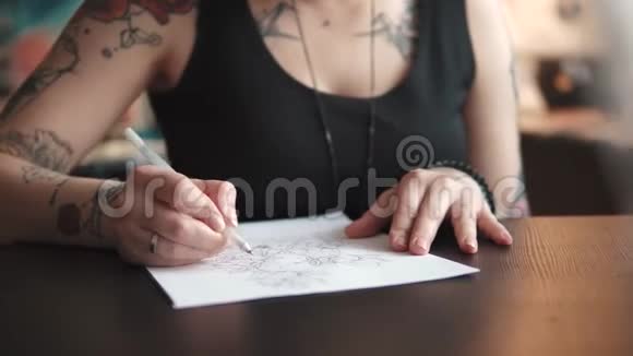 纹身师在一个家庭工作室里用纸做纹身素描视频的预览图