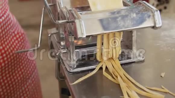 用传统风格的意大利面机做意大利面烹饪过程接近厨师使用面食切割机视频的预览图